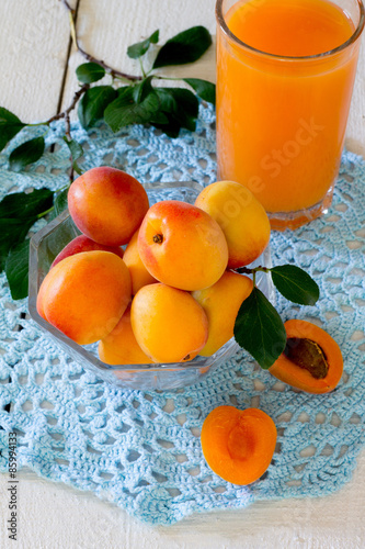  Fresh sweet apricot juice and fresh apricots on wooden table