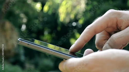 Close -up men using a smart-phone in the park
