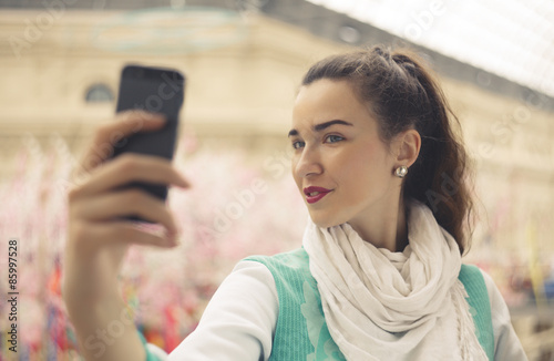 stylish young woman is taking selfie on her mobile phone