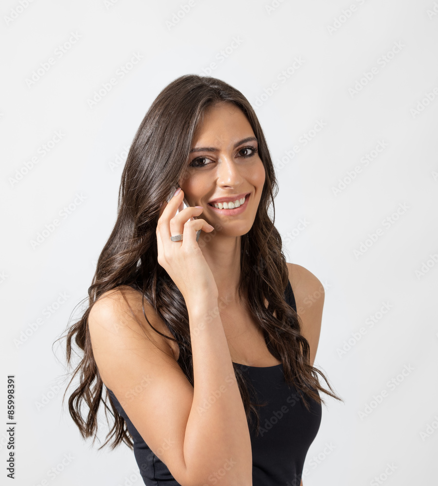 Fototapeta premium Natural tanned beauty smiling while talking on the cellphone 