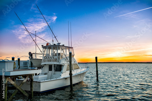 fishing boat on the pier at sunset on the lake