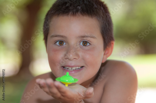 niño jugando a la peonza en el parque 