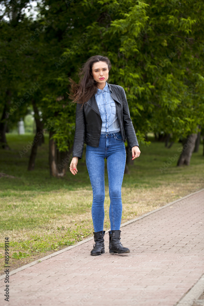Young beautiful girl in blue jeans and a blue shirt on the backg Young beautiful girl in blue jeans and a blue shirt on the backg