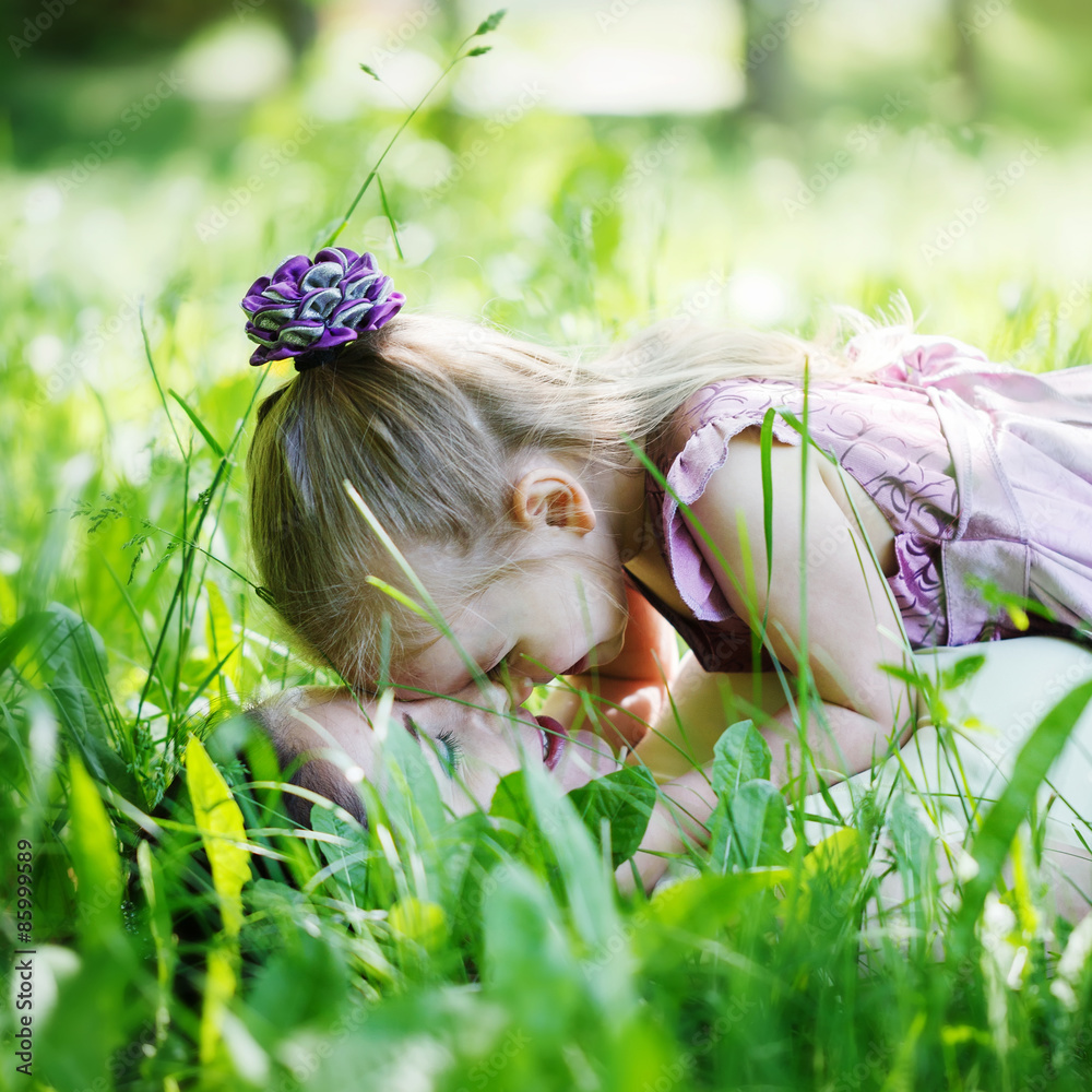 Naklejka premium happy family. Mother and daughter lie on a grass, embrace in t
