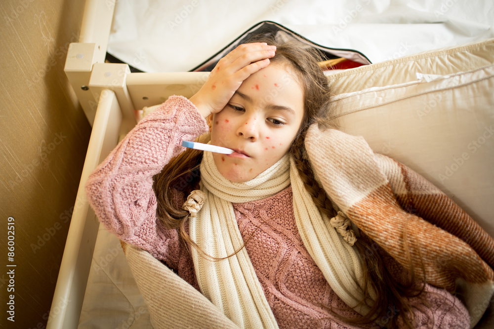 Samolepka sick girl with chickenpox lying in bed and measuring temperature