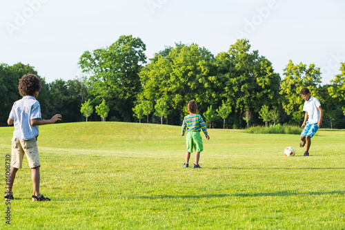Three kids are playing football.
