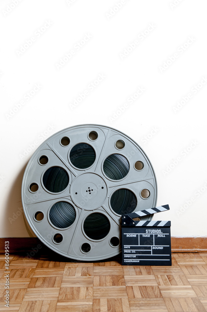 Cinema movie roll with clapper on wooden floor