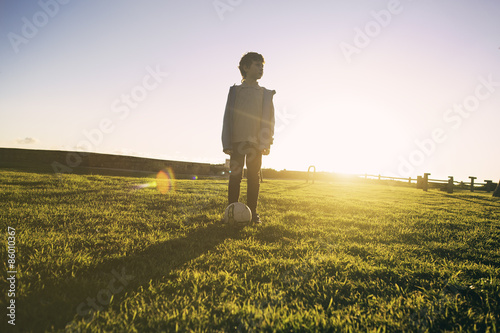 Portrait of a boy staying on green grass with soccer ball  © x4wiz