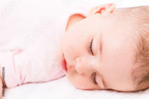 Close-up portrait of a beautiful sleeping baby on white