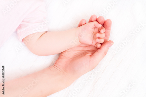 Beautiful sleeping baby with mom hand on white background
