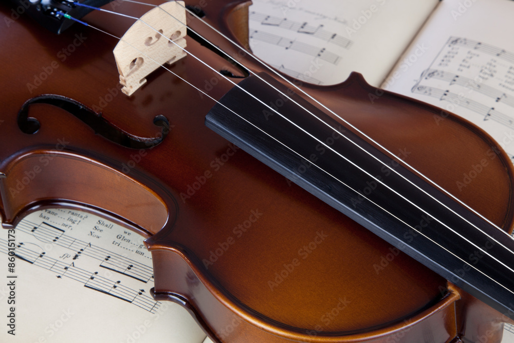 Fototapeta premium Violin resting on open sheet music book