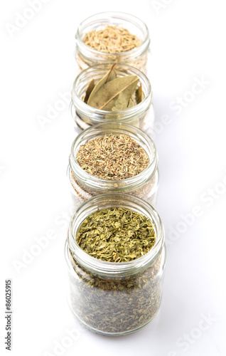 Herbs variety of rosemary, parsley, bay leaves and thyme in mason jars 