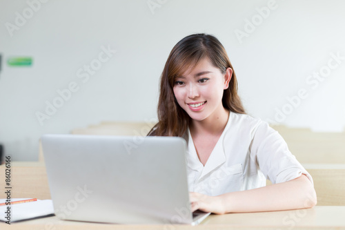 Asian beautiful female student study with laptop in classroom