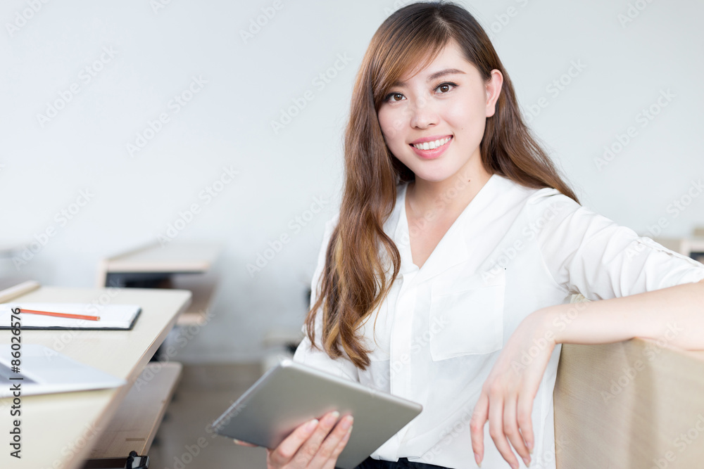 Asian beautiful female student study with tablet in classroom Asian beautiful female student study with tablet in classroom