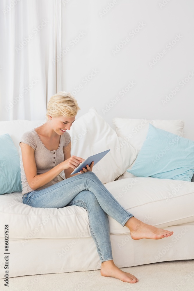 Smiling blonde woman using her digital tablet 