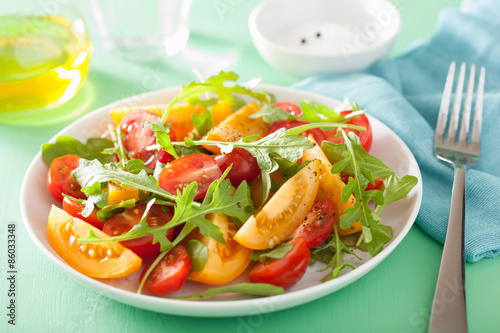 tomato salad with arugula over green background