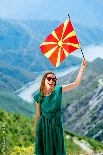 Woman with macedonian flag on the top of mountain