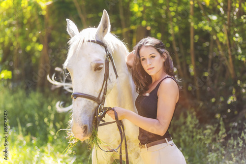 Outdoor photo from a beautiful young women with her horse