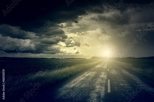 Asphalt road and dark storm clouds over it 