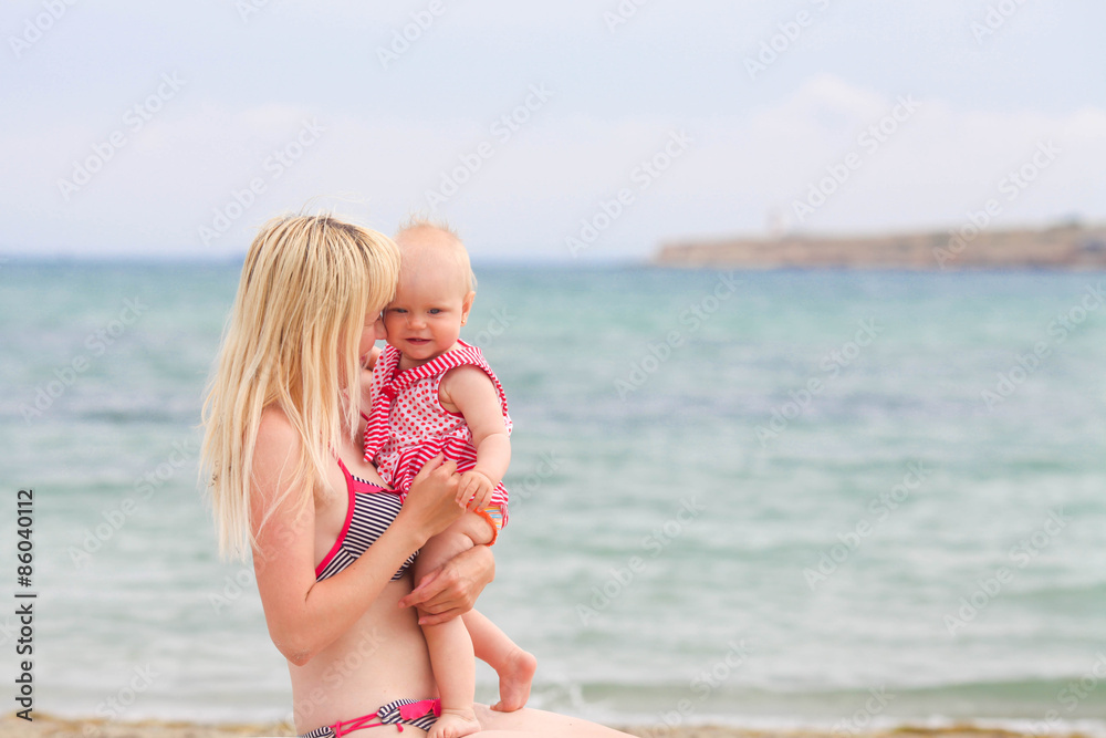 Naklejka premium Mother holds the child on hands at the sea