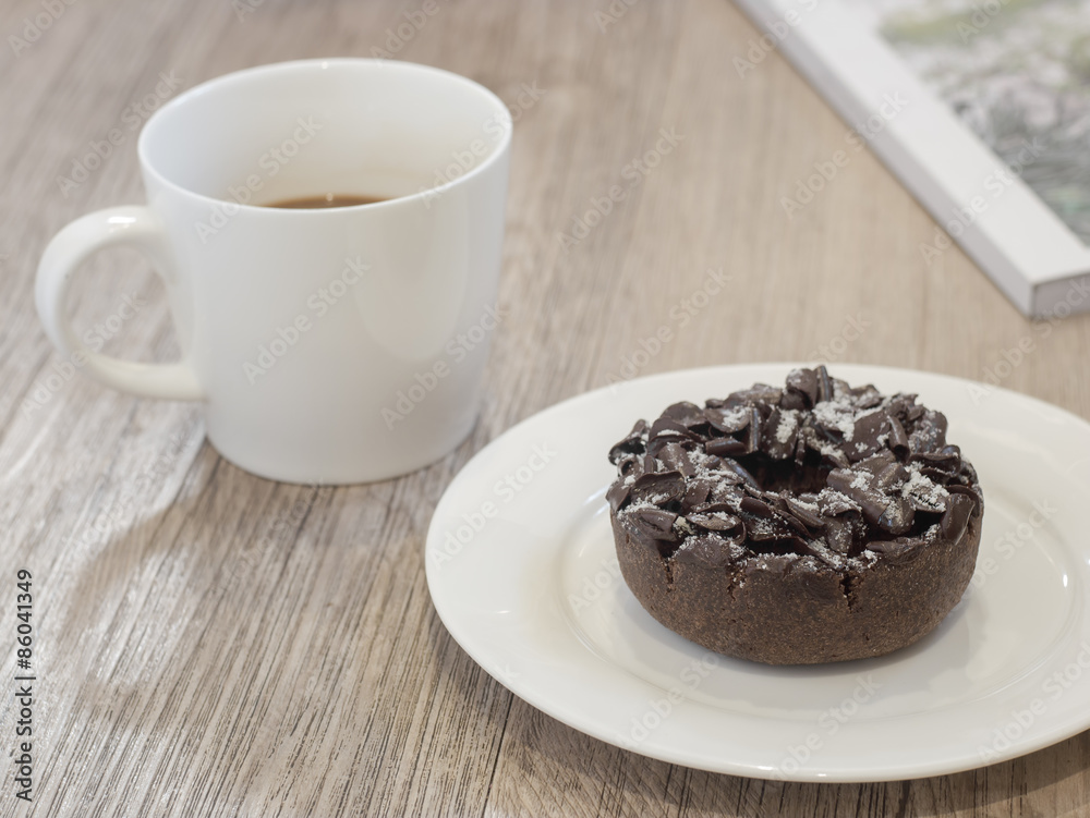 Chocolate Donut and cup of coffee on wooden background