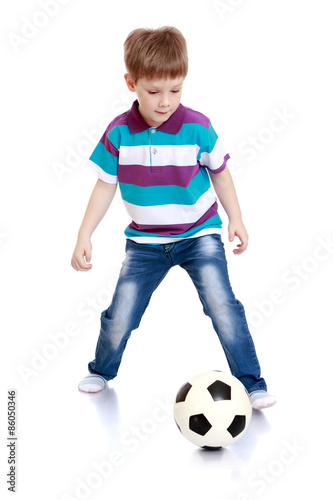The cheerful little boy playing football