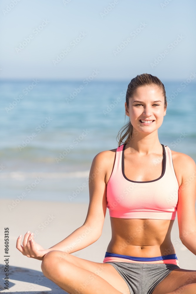Fit woman doing yoga beside the sea 