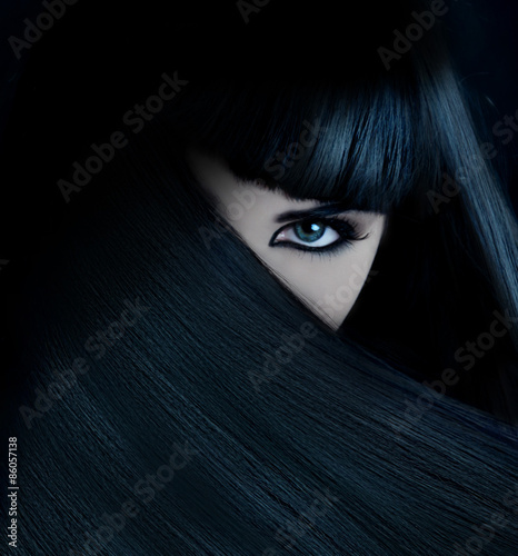 mysterious brunette wth hai covered face and aquamarine eyes