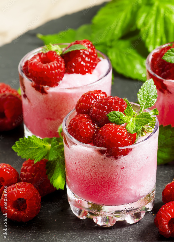 Raspberry granita with berries and mint in glass cups, selective Raspberry granita with berries and mint in glass cups, selective