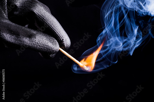 Close-up of hand with match flame photo