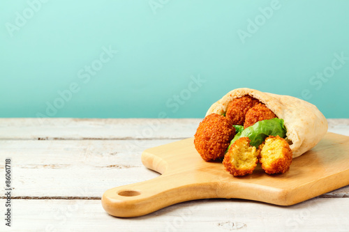 Falafel balls served with pita and lettuce on a wooden board