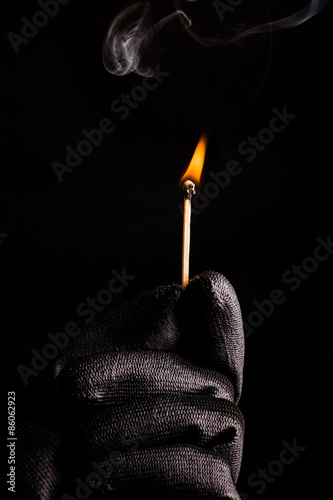 Close-up of hand with match flame