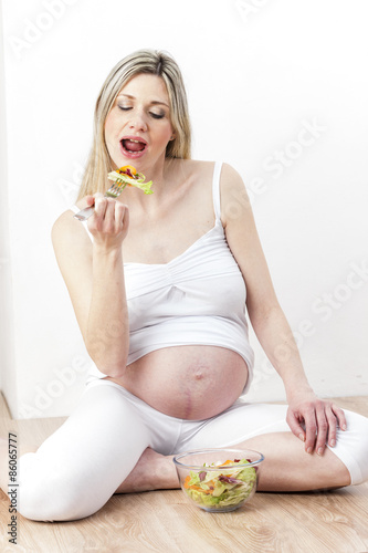portrait of pregnant woman eating vegetable salad