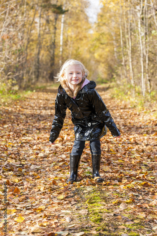 little girl wearing rubber boots in autumnal nature