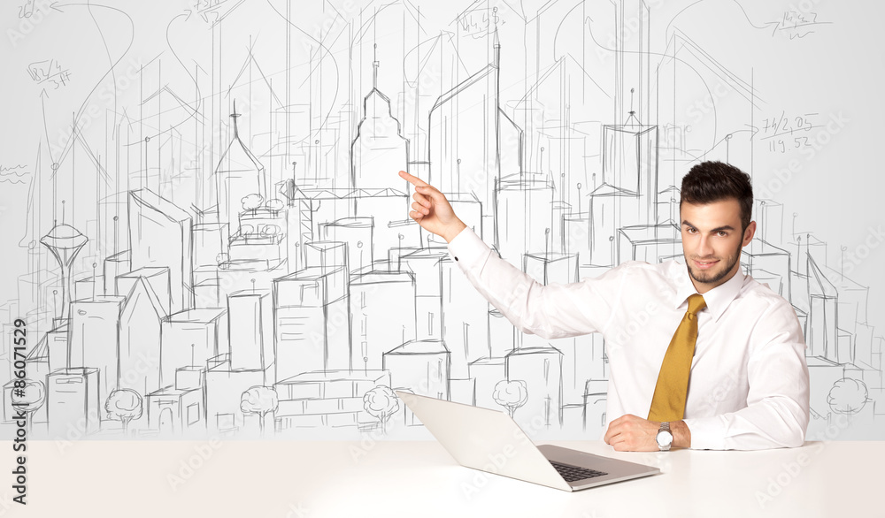 Businessman sitting at the white table with hand drawn buildings Businessman sitting at the white table with hand drawn buildings