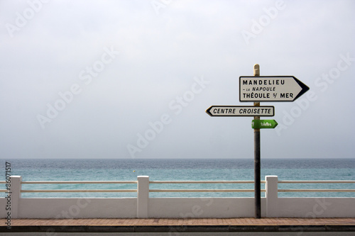 two signs in front of the sea