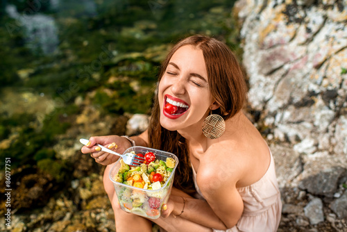 Photo Woman eating healthy salad near the river