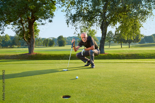 Senior golfer bevor putting II