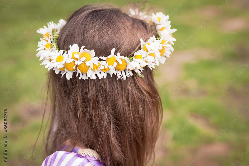 Naklejka premium wreath made with camomile flowers on a little girl's head
