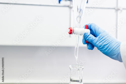 Woman working with a Funnel in a Lab photo