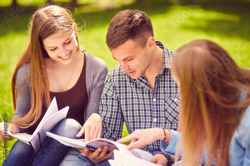 Group of college students exchanging notes outdoors