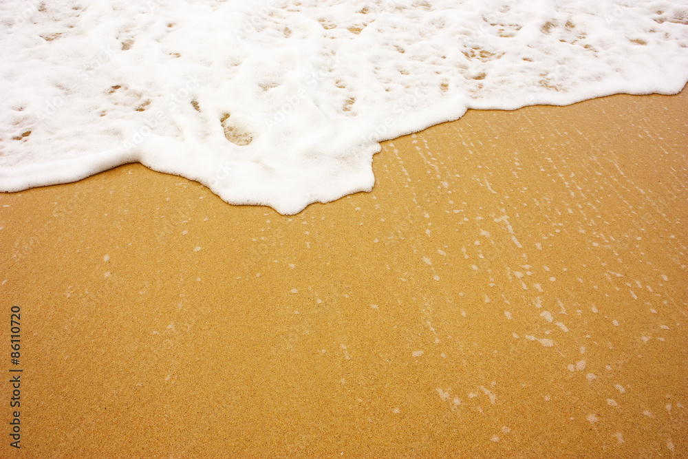 Sea wave with foam on sand