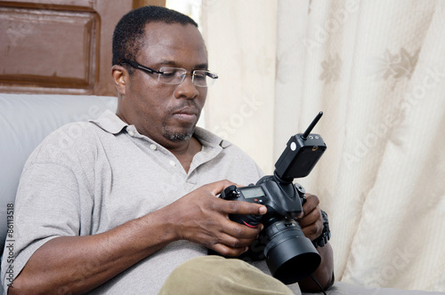 African photographer looking at the screen of his digital camera