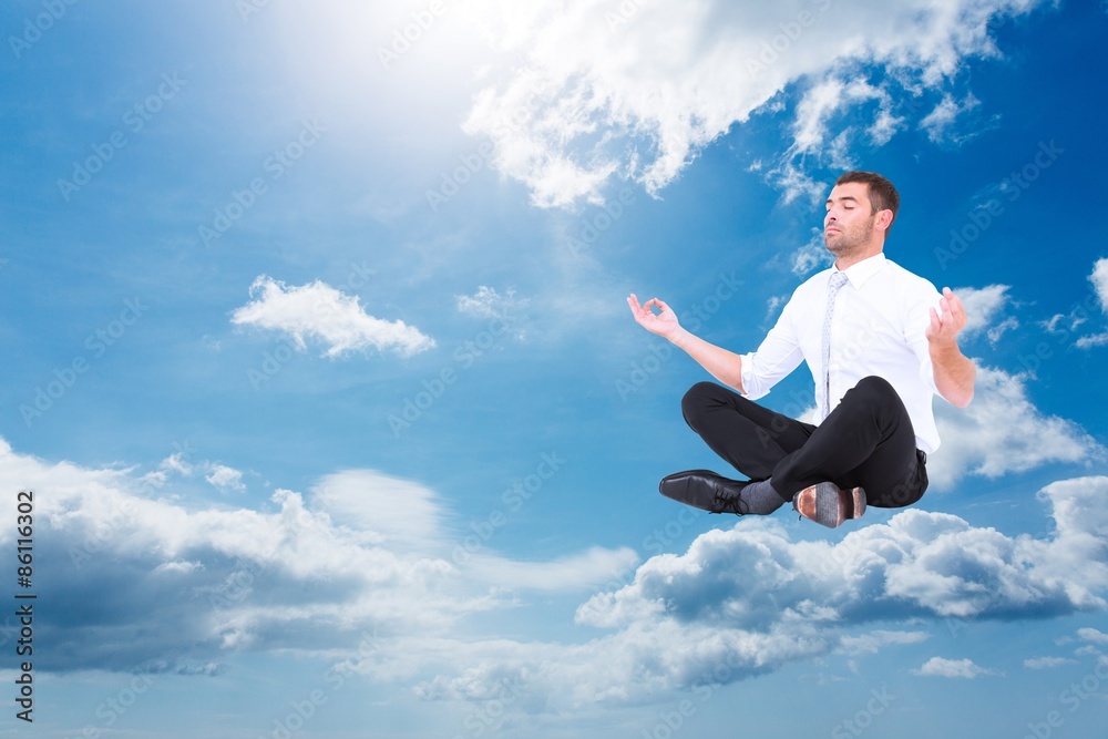Composite image of businessman meditating in lotus pose Composite image of businessman meditating in lotus pose