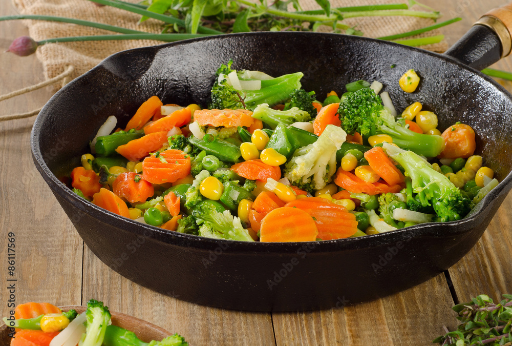 Stir fried vegetables in a skillet . Stir fried vegetables in a skillet .