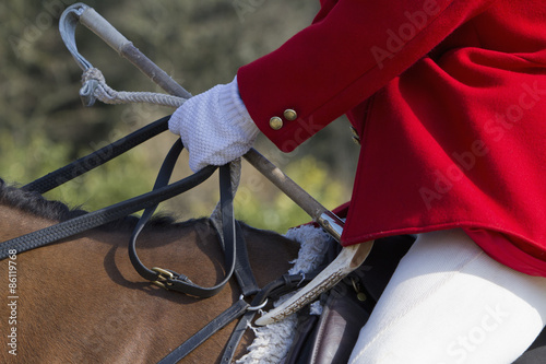 A Master of Foxhounds in a traditional hunting coat, on horseback.  photo