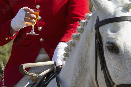 A Master of Foxhounds having a drink at a hunt meet. 
