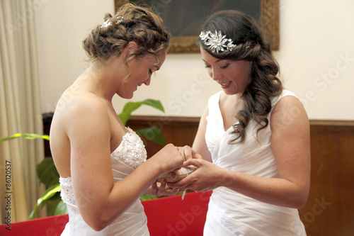 two brides getting married exchange rings photo