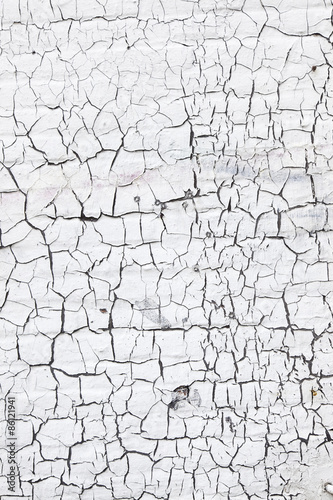 abstract pattern of cracks in white washed wall