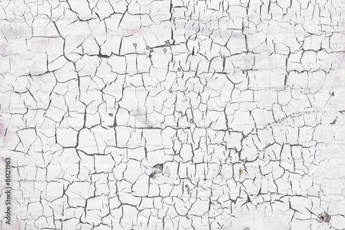 abstract pattern of cracks in white washed wall